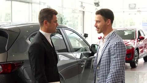 Men finalize a successful car purchase with a handshake Stock Footage 311985466