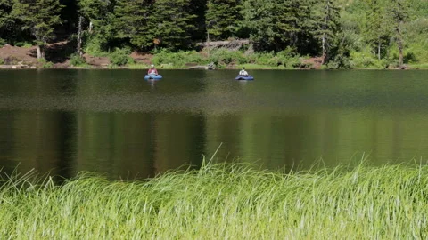 Men on float tubes fish on a mountain lake, 4K Stock Footage 231540306