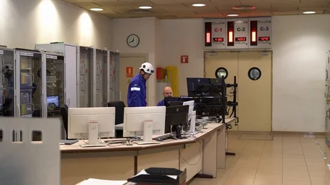 Men in front of monitors control a nuclear reactor at a power plant. Stock Footage 122222132