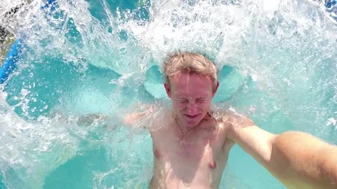 Men funny fall back into courtyard house outdoor pool Stock Footage 305237422