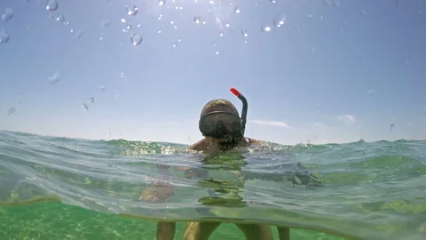 Men with googles diving into the crystal clear sea Stock Footage 91587314