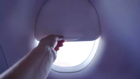 Men hand opens the airplane window Stock Photos