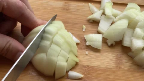 Men hands are cutting a onion in half on wooden cutting board in close-up 스톡 동영상 233627937