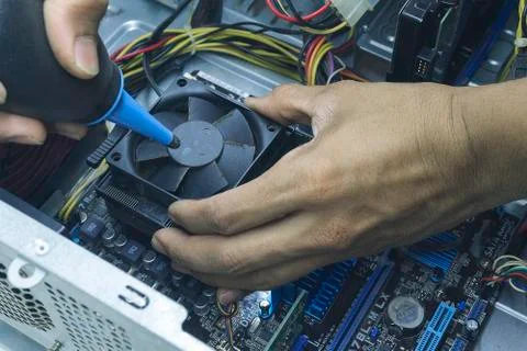 Men hands of Computer technician Cleaning the CPU fan of the computer. Stock Photos