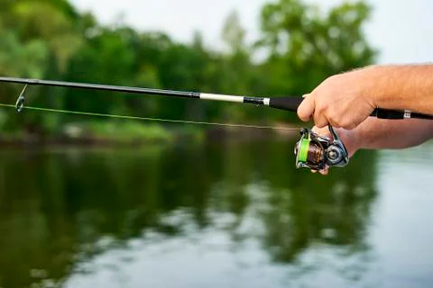 Men hands kept spinning on the background of the river Stock Photos