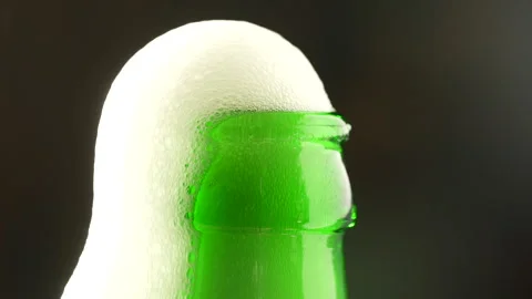 Men hands open bottle of beer. Beer foam coming out of green beer bottle Stock Footage 293234977