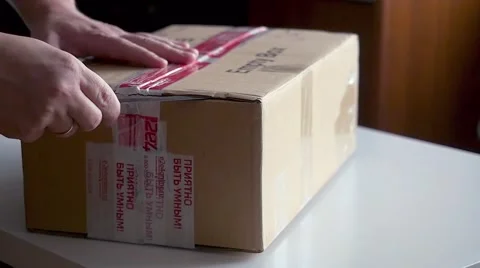 Men hands opens cardboard box. Taking postal parcels computer details Stockbeeldmateriaal 56278743