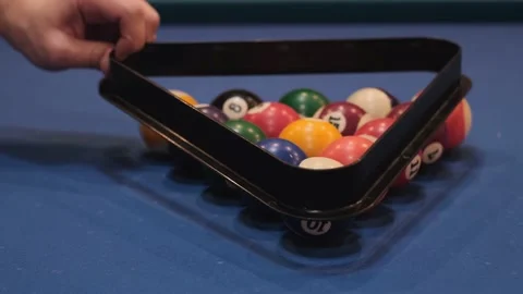 Men hands place pyramid of white balls with help of triangle on billiard table a Stock Footage 237006802