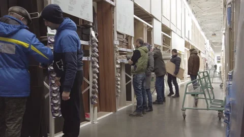 Men in a hardware store choose lumber and boards for repair Stock Footage 138073222