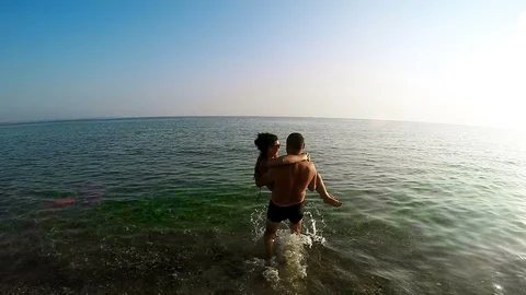 Men is having fun with girlfriend into the crystal clear sea while on vacation Stock Footage 91587202