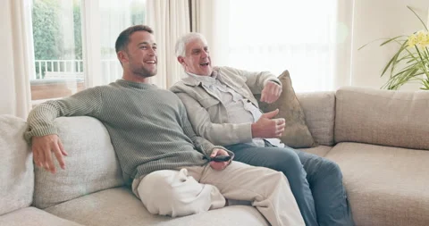 Men, high five and watching tv with dad in home, entertainment or bonding with Stock Footage 341431339