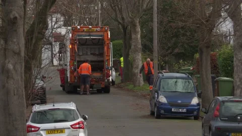 Men in high visibility orange clothes emptying garden waste Stock Footage 145909032