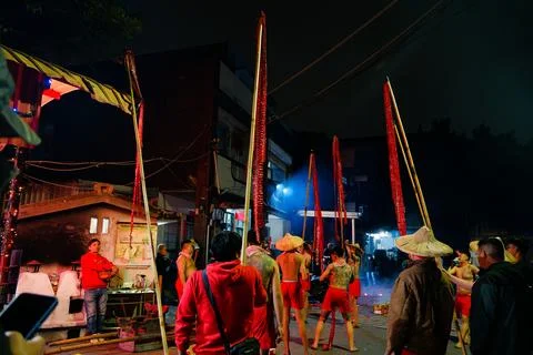 Men Hold Long Firecracker Strings on Poles at Shezidao Lantern Festival Fotos Stock