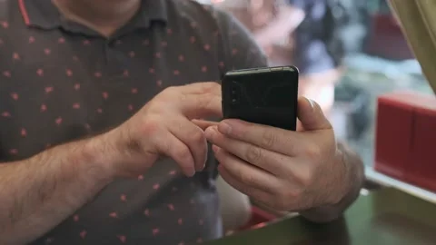 Men holding cell phone using smartphone device in a street cafe. Man blogger Stock Footage 218071749