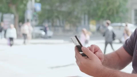 Men holding cell phone using smartphone device in a street cafe. Man blogger Stock Footage 219907749