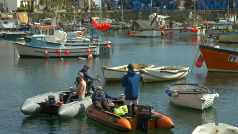Men in inflatable motor boats preparing to leave a busy harbour. Stock Footage 287485836