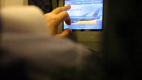 Men inside airplane playing with the tv touchscreen Stock Footage 125162514