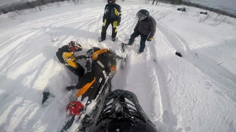 Men inspect a snowmobile and one of them falls into a snowdrift Stock Footage 102206971