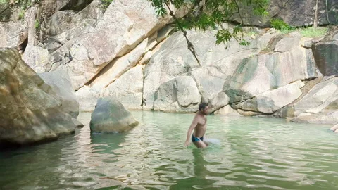 Men jumping from rope swing. Bungee ride across lake. Stock Footage 257056024