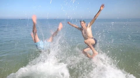 Men jumping in the sea. 库存影片 47978346