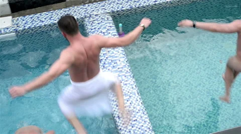 Men jumping in swimming pool 库存影片 62635058