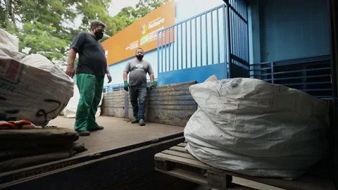 Men load a large bag of used computer parts on a truck to take the a Video stock 149792997