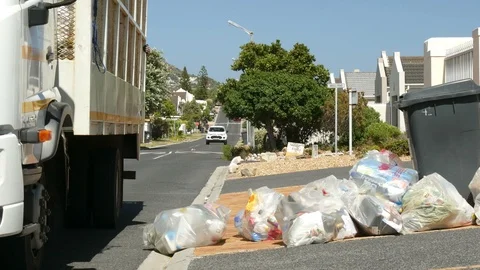 Men loading truck with recycling garbage from side walk, blue sky Stock Footage 102018255