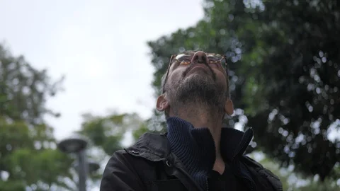 Men look up at the sky and open umbrella Stock Footage 100877089