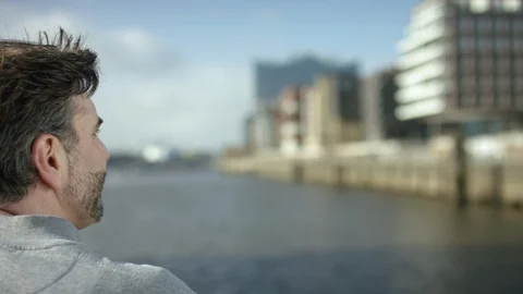 Men is looking over a river and is thinking about his future in a modern dist Stock Footage 97848833