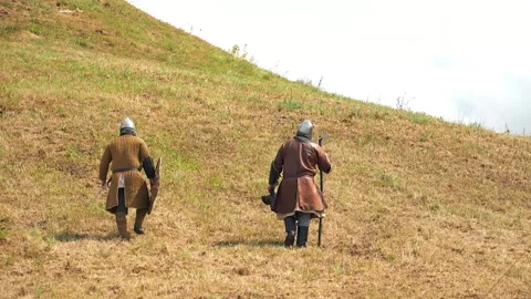 Men in medieval warrior clothes walk away 스톡 동영상 283461636