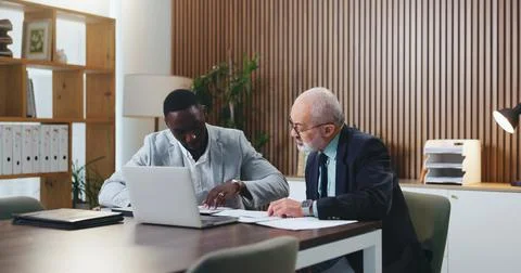 Men, mentor and documents with laptop at office with planning, review and c.. Stock Photos