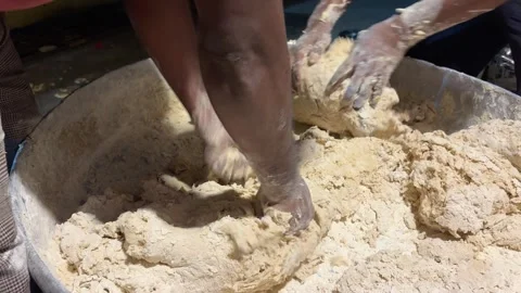 Men mixing dough in a large container during an Indian wedding celebration Stock Footage 329237202