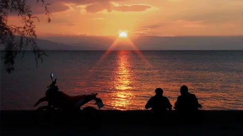 Men with Motorcycles are Sitting on the Beach at Sunset Stock Footage 100614541