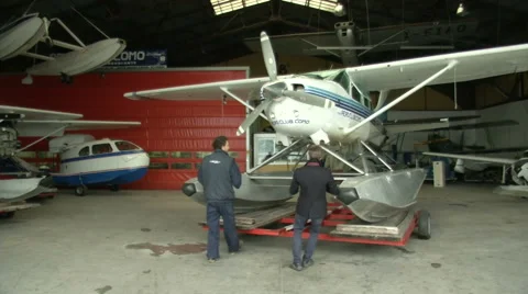 Men moving float plane outside hangar  Stock Footage 43316812