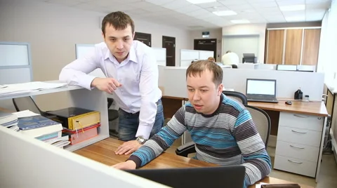 Men in the office discuss work issues standing in front of the computer Stock Footage 63086398