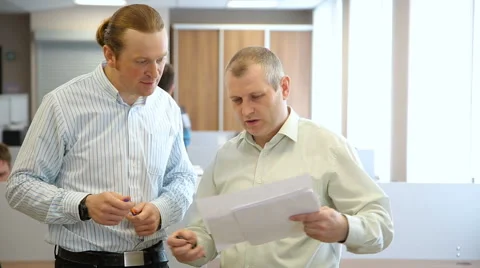 Men in the office looking documents and talking Stock Footage 63131657