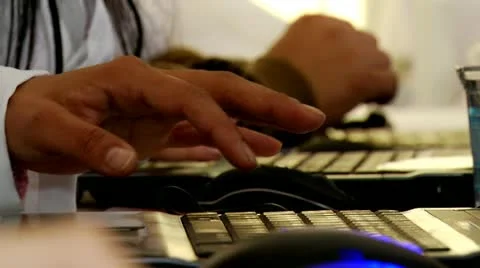 Men in office typing on keyboard with light in background Stock Footage 14470114