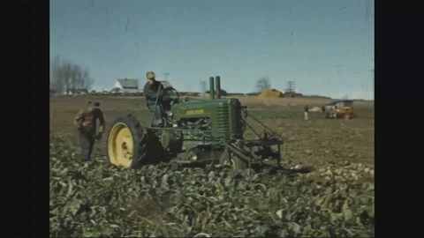 Men operate a John Deere experimental harvester to collect sugar beets - 1941 Stock Footage 102216297