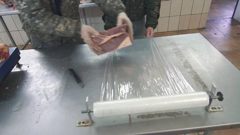 Men pack meat in cellophane Stock Footage 82901636