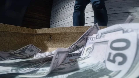 Men packing dollar bills in to briefcase Video stock 97837992