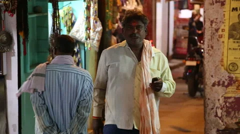 Men passing down the bazaar street in evening in Varanasi. Stock Footage 50346938
