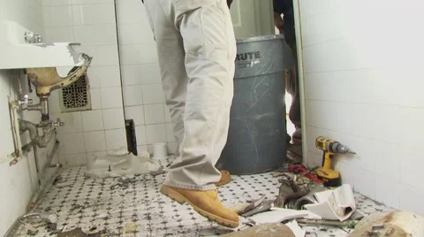 Men picking up debris from bathroom Stock Footage 55570852
