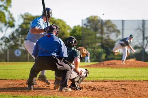 Men playing baseball game. Batter getting ready to hit a pitch during ballg.. Stock Photos
