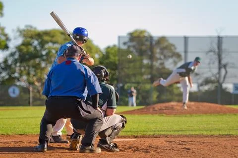 Men playing baseball game. Batter getting ready to hit a pitch during ballg.. Stock Photos