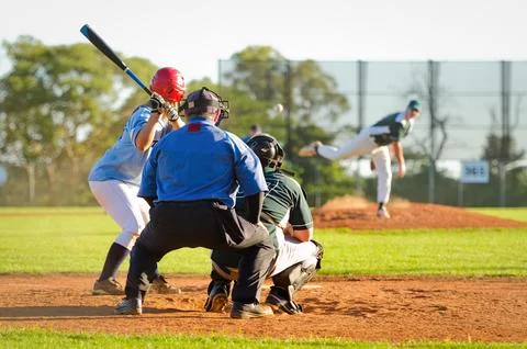 Men playing baseball game. Batter getting ready to hit a pitch during ballg.. Stock Photos