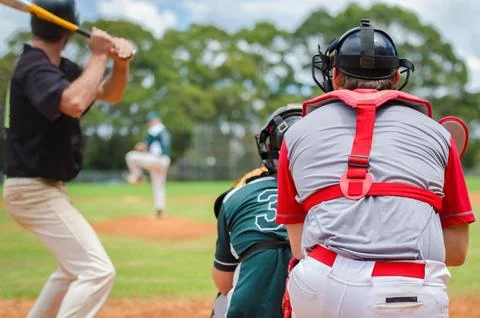Men playing baseball game. Batter getting ready to hit a pitch during ballg.. Stock Photos