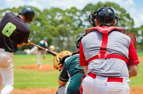 Men playing baseball game. Batter getting ready to hit a pitch during ballg.. Stock Photos