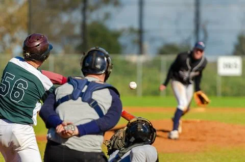 Men playing baseball game. Batter getting ready to hit a pitch during ballg.. Stock Photos