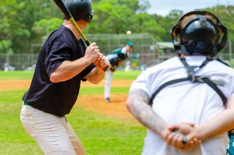 Men playing baseball game. Batter getting ready to hit a pitch during ballg.. Stock Photos