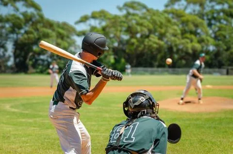 Men playing baseball game. Batter getting ready to hit a pitch during ballg.. Stock Photos